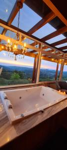 a large bath tub in a room with a large window at Josef’s Chalé in Nova Petrópolis