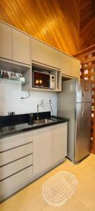 uma cozinha com um frigorífico de aço inoxidável e um micro-ondas em Josef’s Chalé em Nova Petrópolis
