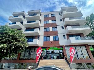 a tall building with red signs in front of it at Iris Apartament Eforie Nord in Eforie Nord