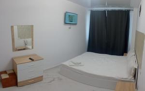 a small bedroom with a bed and a mirror at Iris Apartament Eforie Nord in Eforie Nord