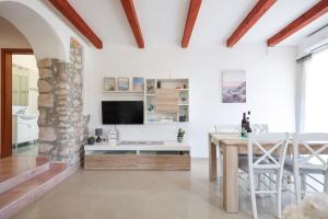 sala de estar blanca con mesa y TV en Apartment M&V, en Zadar