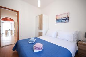 Un dormitorio con una cama azul con toallas. en Apartment M&V, en Zadar