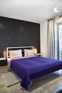 a bedroom with a purple bed with a black wall at Water Lily Boutique B&B and Bungalow in Hévíz
