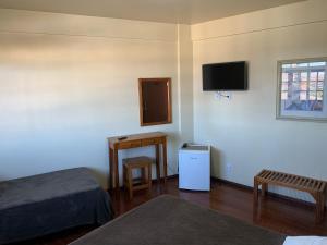 a room with two beds and a tv and a table at Altos da Serra Hotel in São Joaquim +47 photos