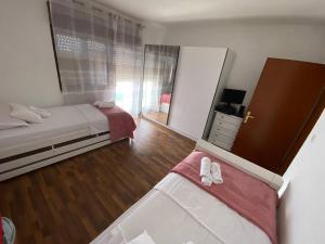 1 Schlafzimmer mit 2 Betten und einem Spiegel in der Unterkunft DaMa in Kaštela