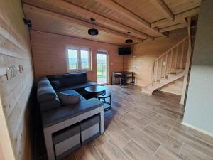 ein Wohnzimmer mit einem Sofa und einem Tisch in der Unterkunft Domki w Bieszczadach Nowa Zelandia in Berezka