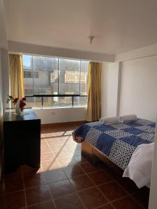 ein Schlafzimmer mit einem Bett und einem großen Fenster in der Unterkunft Departamento Amoblado en el Centro de Cusco in Cusco