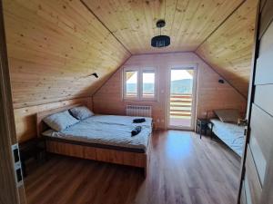 Cette petite chambre comprend un lit dans une cabane en bois. dans l'établissement Domki w Bieszczadach Nowa Zelandia, à Berezka