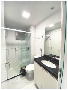 uma casa de banho com uma cabina de duche em vidro e um WC. em Aquarius Residence em Fortaleza