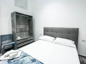 una camera bianca con un letto e una sedia di Natola's Home Beach a Margherita di Savoia