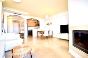 a living room with a white couch and a fireplace at Bermeja view apartment in Manilva +14 photos