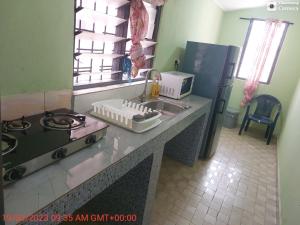 eine Küchentheke mit einer Spüle und einem Herd in der Unterkunft Affordable lovely apartment 3 in Accra