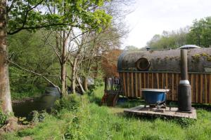 a bath tub sitting on a wooden platform next to an rv at Caban Delor. Off-grid glamping experience. Walking distance into Caernarfon. 20-min drive to Snowdonia or Anglesey. in Caernarfon