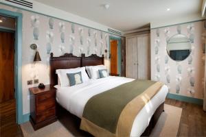 a bedroom with a large bed and a tv on the wall at Morton Hotel in London