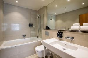 uma casa de banho com um lavatório, uma banheira e um WC. em Morton Hotel em Londres