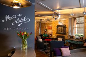 a restaurant with a vase of flowers on a table at Morton Hotel in London