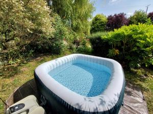 a hot tub in a yard with a swimming pool at L'authentique Tonneau à Cidre d'Emma in Litteau