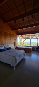 1 dormitorio grande con 1 cama y ventana grande en Josef’s Chalé en Nova Petrópolis