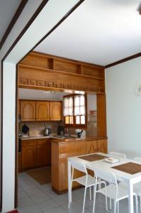 a kitchen with wooden cabinets and a table and chairs at View of the Castle and the Sea 1 in Platamonas
