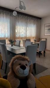 un orsacchiotto di peluche seduto di fronte a una sala da pranzo di B&B Da Leone a Palazzolo dello Stella