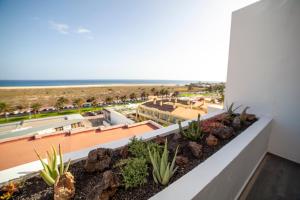 una vista sulla spiaggia dal balcone di un edificio di Amazing Luxury Apartment, La Casa del Corazon a Morro del Jable