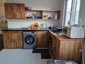 a kitchen with a washing machine and a microwave at Le Manguier in Mahébourg