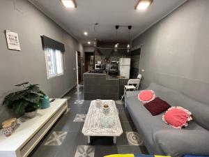 a living room with a couch and a table at CASA RURAL A PIE DE PLAYA Remodelada 2024 in Chipiona