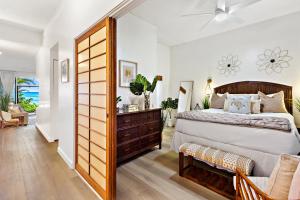 a bedroom with a large bed with a wooden door at Hale Mahina A103 in Kahana +23 photos
