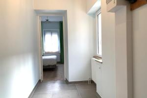 un couloir avec une chambre avec un lit et une fenêtre dans l'établissement Appart'Village Le Creusot N4 NeufNetflix, au Creusot