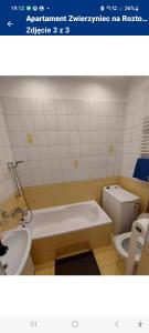 a bathroom with a tub and a toilet and a sink at Apartament Zwierzyniec na Roztoczu in Zwierzyniec