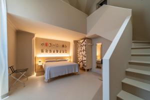 Palazzo Vergine - by Inside Salento في غالّيبولي: غرفة نوم مع سرير وسلالم في منزل