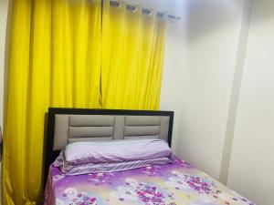 a bedroom with a bed with a yellow curtain at Chalet golf porto marina in El Alamein