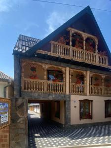 a building with a balcony with flowers on it at Acasa la Tulucu in Bîrsana