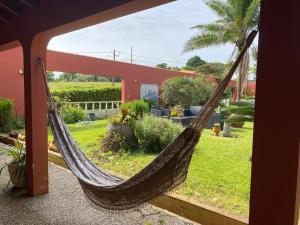 a hammock in front of a house with a yard at A Casa do Comandante - Piscina e Jardim in Lagoa