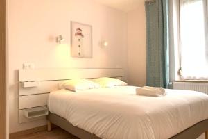 Schlafzimmer mit einem weißen Bett und einem Fenster in der Unterkunft Appart'Village Le Creusot N2 NeufNetflix in Le Creusot
