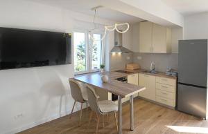 a kitchen with a table and chairs and a refrigerator at Vigo in Rijeka