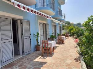 eine Terrasse mit Tischen und Stühlen in der Unterkunft Bluflest in Dhërmi