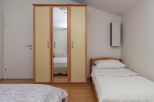 a bedroom with two beds and a mirror at Apartman Marin in Makarska