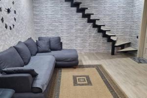 - un salon avec un canapé et un escalier dans l'établissement My House, à Bordjomi