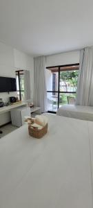 a bedroom with a bed with a basket on the floor at ILOA Residence Flat Alagoas in Barra de São Miguel