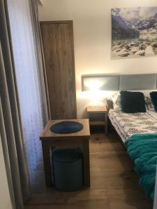 een slaapkamer met een bed en een tafel en een bed en een raam bij Pokój 2 osobowy z aneksem kuchennym in Zakopane