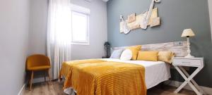 a bedroom with a bed with a yellow blanket on it at Cruces Hospital Metro in Barakaldo