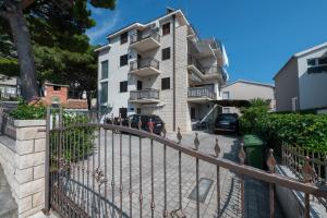 a building with a fence in front of it at Apartman Marin in Makarska