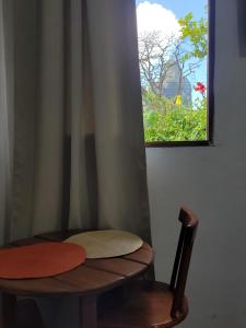 a wooden chair with a window in a room at Batera House Noronha in Fernando de Noronha