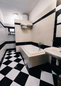 a bathroom with a black and white checkered floor at Chatka Gatterhof in Hodruša