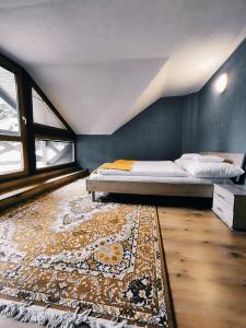 a bedroom with a bed and a rug at Chatka Gatterhof in Hodruša