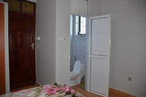 a bathroom with a toilet and a room with a door at Elly's Classic Villa in Dar es Salaam
