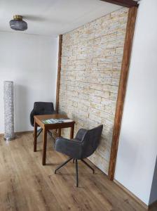 um quarto com uma cadeira, uma mesa e uma parede de tijolos em Ferienappartement 2 beim Strandbad em Reifnitz