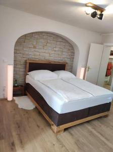un grande letto in una stanza con muro di mattoni di Ferienappartement 2 beim Strandbad a Reifnitz