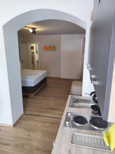 uma cozinha com um fogão e uma cama num quarto em Ferienappartement 2 beim Strandbad em Reifnitz